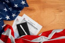 U.S. flag with paperwork and pen on wooden desk related to apostille process