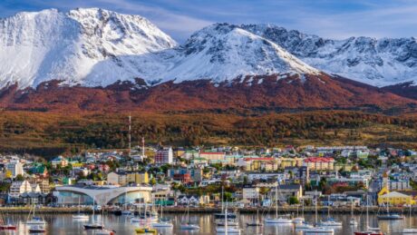 colorful scene view of the bay and ushuaia city against snow capped andes mountains during autumn season, tierra del fuego, patagonia, argentina