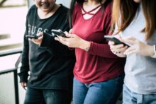 Tres personas usando sus celulares, posiblemente jugando en casinos online