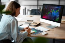 Mujer analizando gráficos de trading en una pantalla de computadora