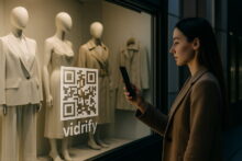 Mujer escaneando un código QR en la vidriera de una tienda de ropa con maniquíes