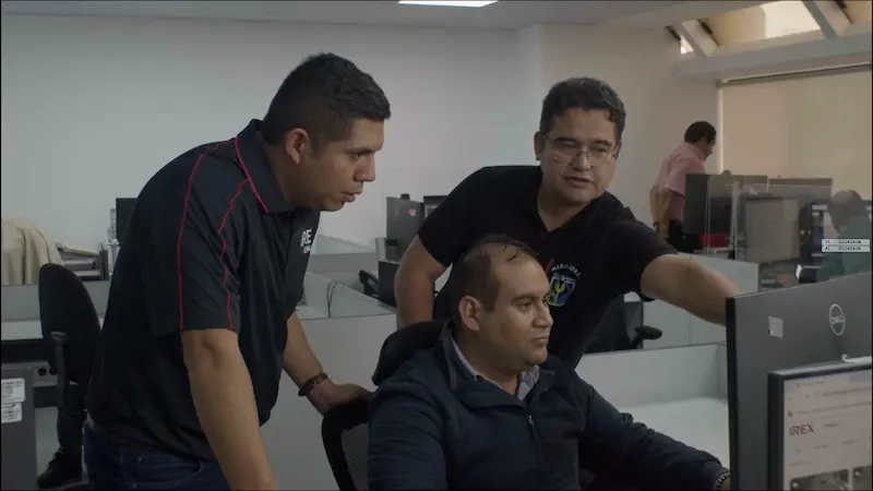 Equipo de seguridad pública colaborando frente a una computadora con software de vigilancia
