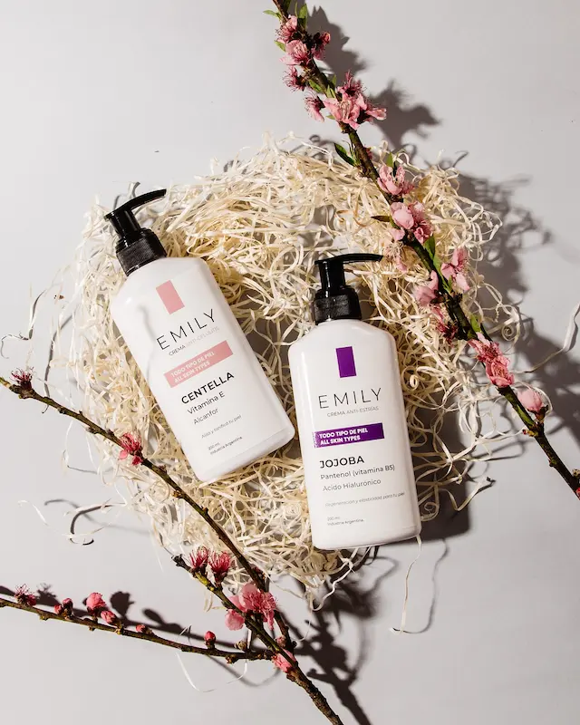 Cremas Emily Cosmetic Centella y Jojoba presentadas en fondo decorativo con flores