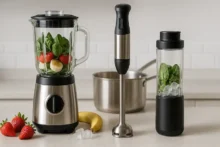 Tres licuadoras en cocina minimalista: de vaso con frutas, de inmersión de acero y personal con hielo, en formato horizontal sin texto
