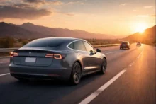 Tesla Model 3 gris circulando por una autopista de Estados Unidos al atardecer, imagen para nota sobre conducción asistida