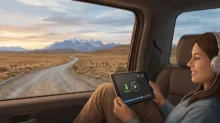 Persona en el asiento trasero de un auto viendo un video en una tablet con icono de descarga, con paisaje patagónico de fondo