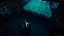 Analista observa una pantalla con esquema táctico de fútbol y métricas del partido