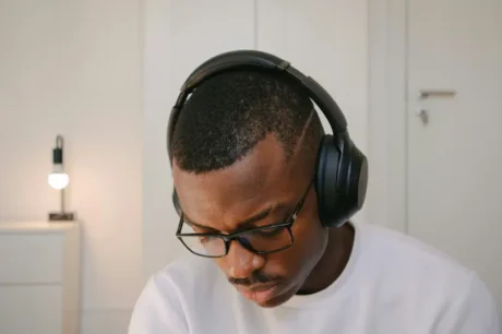 Man wearing black over-ear headphones and glasses indoors