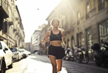 Mujer corriendo con auriculares por una calle urbana durante un entrenamiento