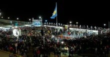 Multitud reunida durante la Vigilia de Malvinas en Río Grande, con una gran bandera argentina y escenario iluminado de noche