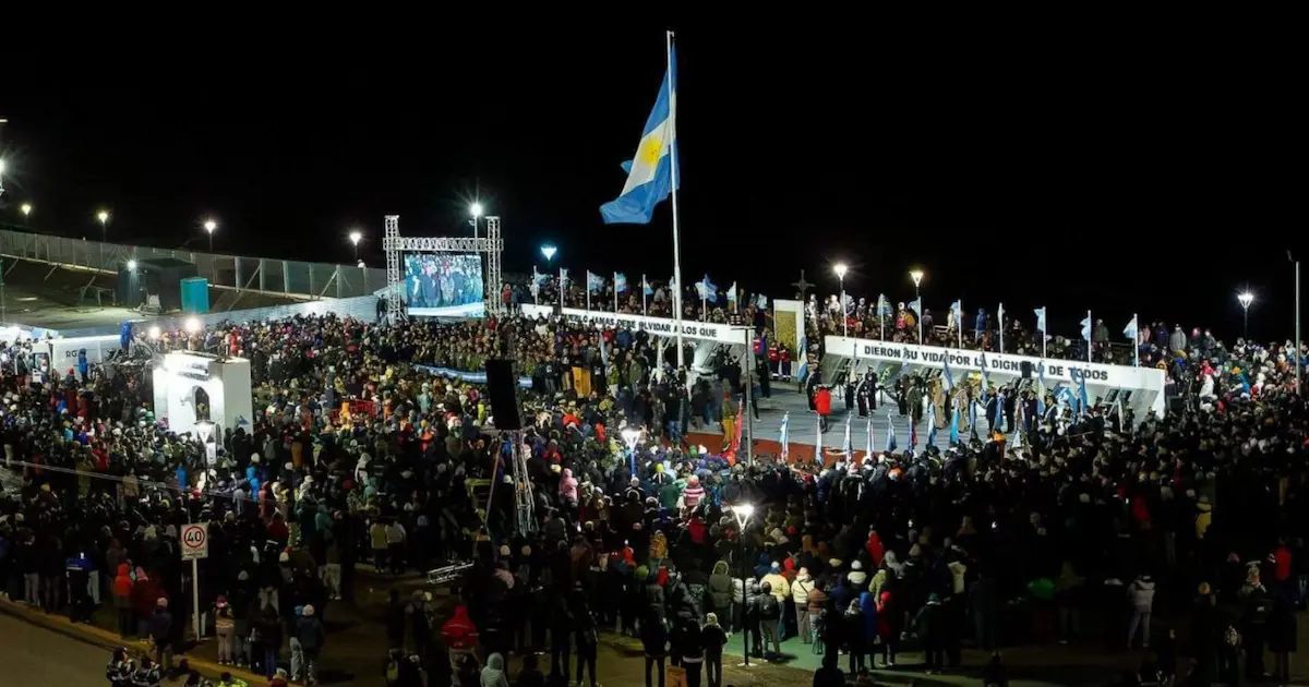 Multitud reunida durante la Vigilia de Malvinas en Río Grande, con una gran bandera argentina y escenario iluminado de noche