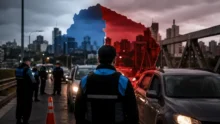 Control policial en un acceso a CABA con autos detenidos y silueta del conurbano sobre la ciudad