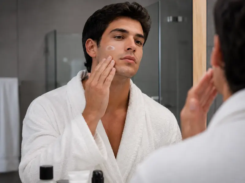 Un hombre cuida su piel usando un rodillo facial de cuarzo