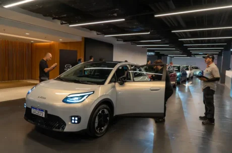 Auto eléctrico AION UT exhibido en un evento de lanzamiento con asistentes en un espacio interior