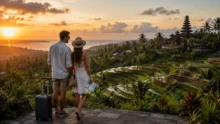 Pareja con valija observa terrazas de arroz y un templo en Bali al atardecer