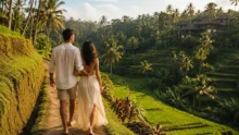 Couple walking along a path above Bali rice terraces and palm-covered hills